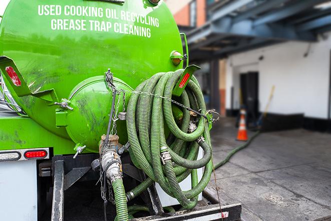 a technician pumping a grease trap in a commercial building in Lynnfield